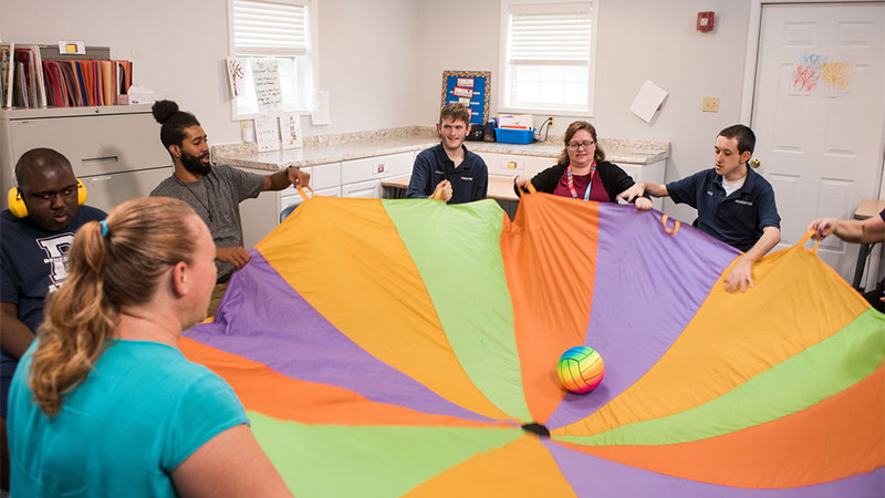 Indoor photo of a group playing with parachute